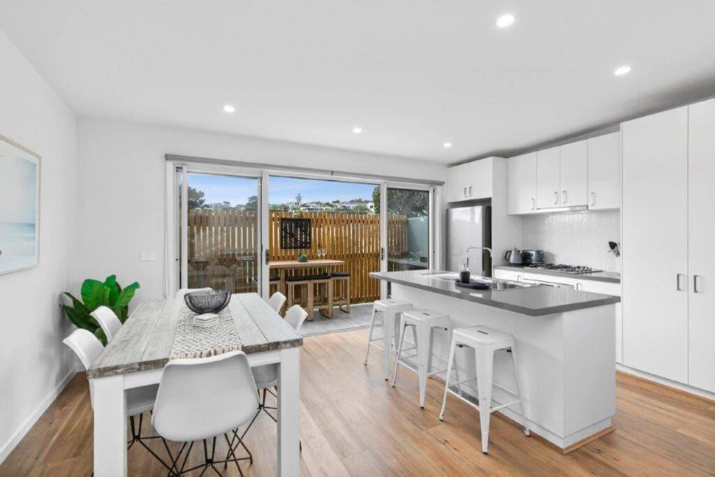 a kitchen and dining room with a table and chairs at CASA EMEC- luxury, aircon, walk to the shops and beach! Outdoor shower and garage parking in Ocean Grove
