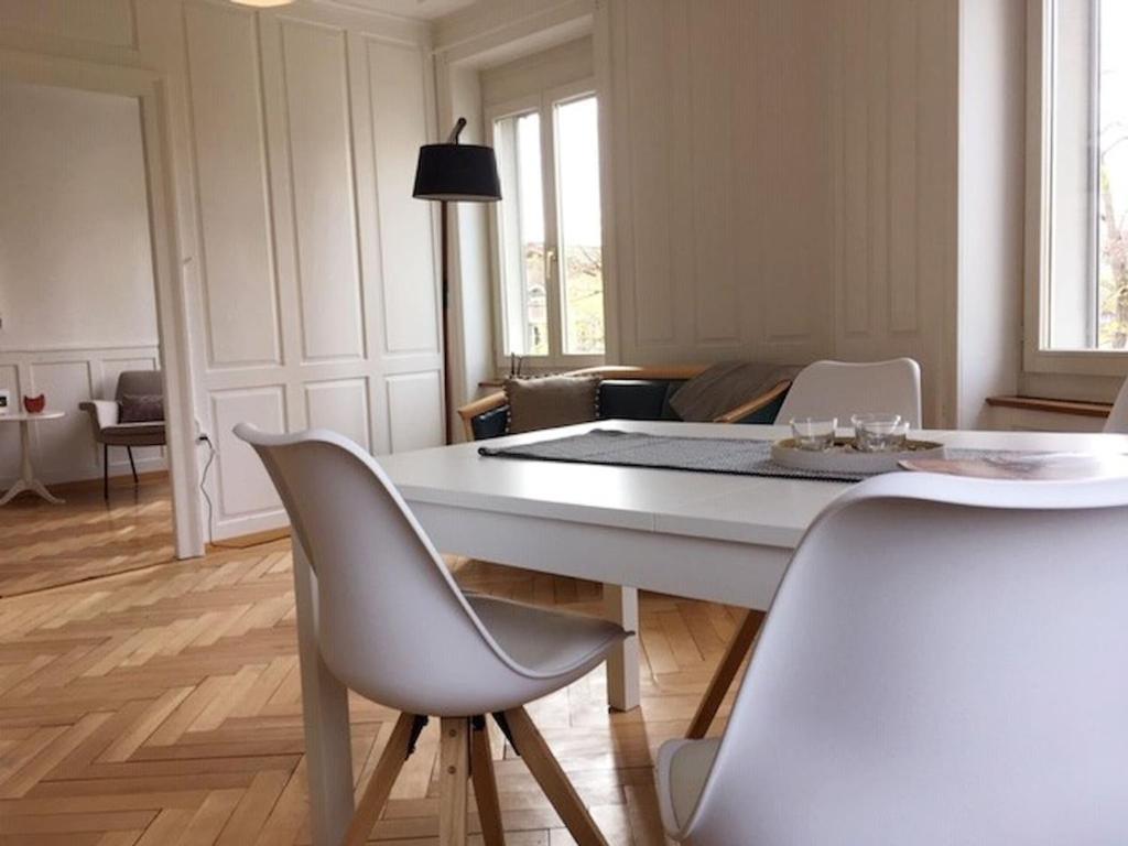 une salle à manger avec une table et des chaises blanches dans l'établissement Casa Schilling 4 Zimmer mit Charme an bester Lage, à Saint-Gall
