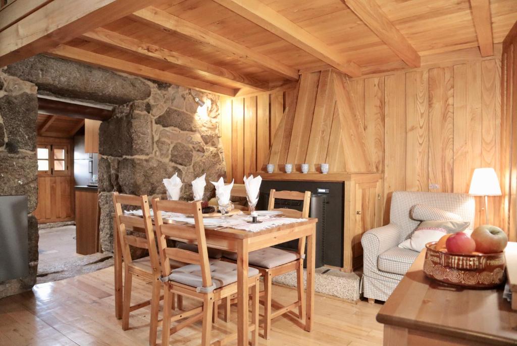uma sala de jantar com uma mesa de madeira e cadeiras em Comfortable rural cottage in ancient village in the Douro region em Viseu