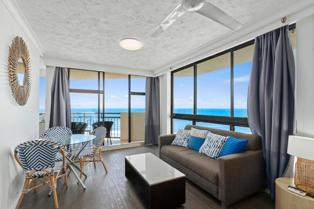 a living room with a couch and a table at Beachcomber Resort - Official in Gold Coast