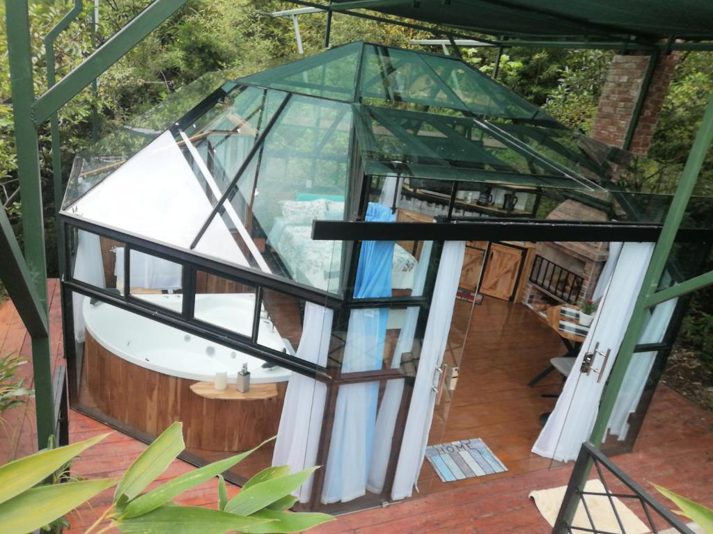 a glass house with a tub in it at Cristal House Mountain View in Heredia