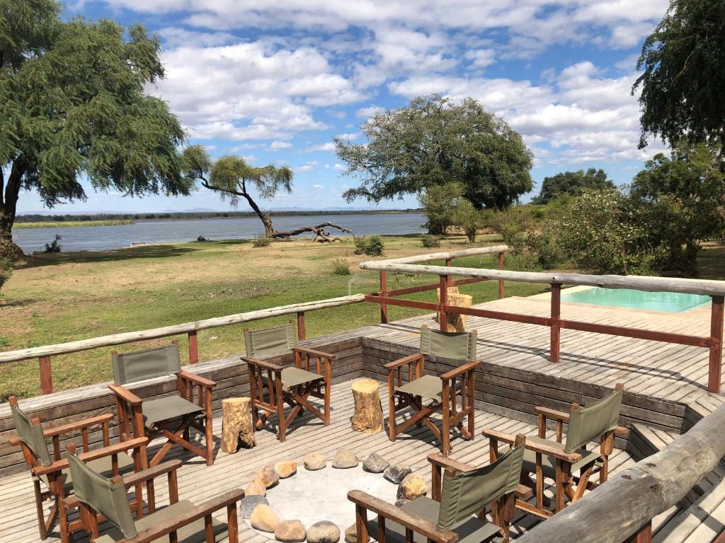 een terras met tafels en stoelen en een zwembad bij Bubezi Camp in Mafuta