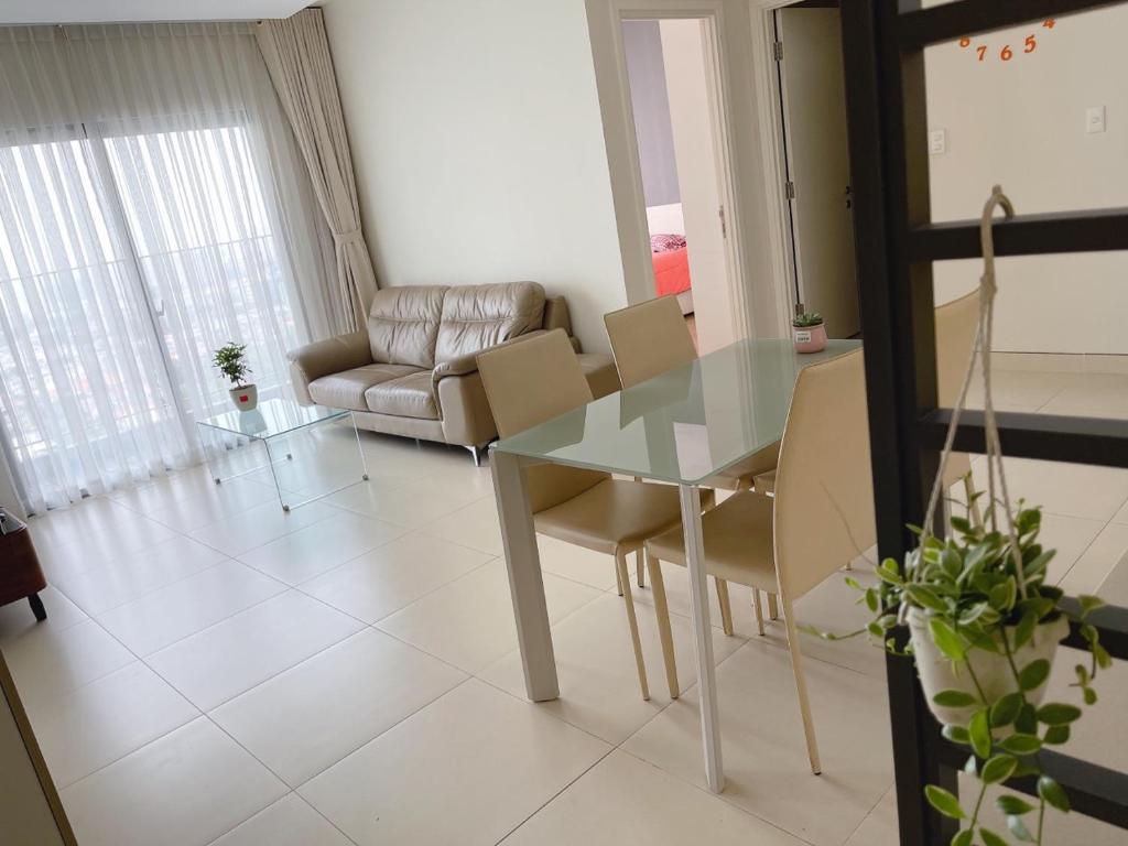 uma sala de estar com uma mesa de vidro e cadeiras em Cozy apartment 2BR - Masteri Thao Dien , D2 em Ho Chi Minh