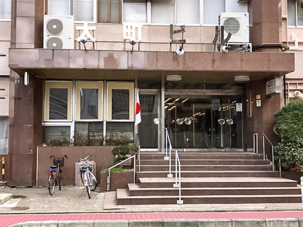 un edificio con escaleras y una bicicleta estacionada frente a él en Ohmachiso en Akita
