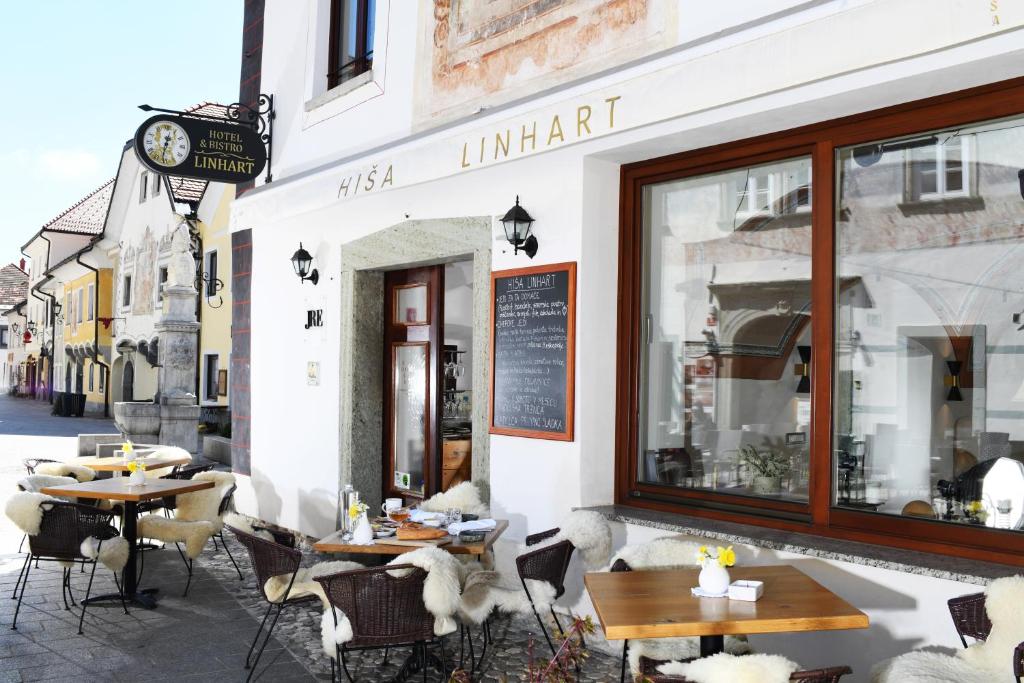 a restaurant with tables and chairs outside of a building at Hiša Linhart, Hotel & Restaurant in Radovljica