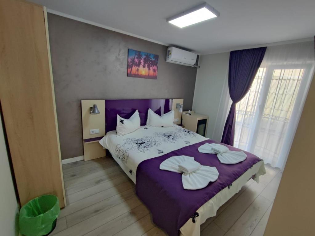 a bedroom with a purple bed with two pillows on it at Casa Martin in Sulina