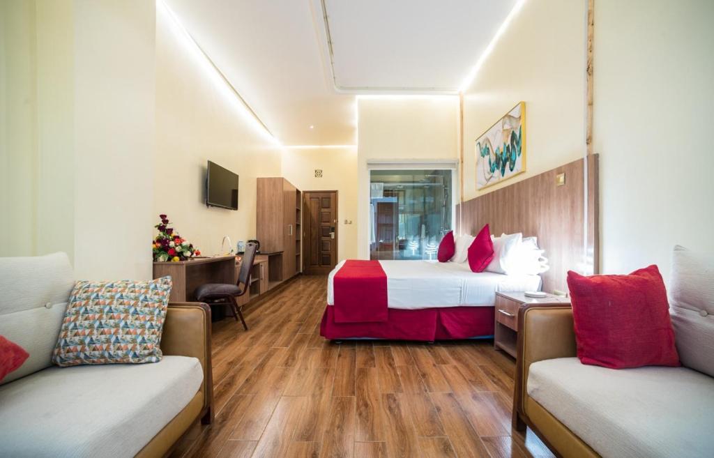 a hotel room with a bed and two couches at Verona Hotel and Conference Center in Ruiru