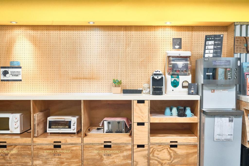 a counter with several microwaves and appliances on it at Bouti City Capsule Inn in Taipei