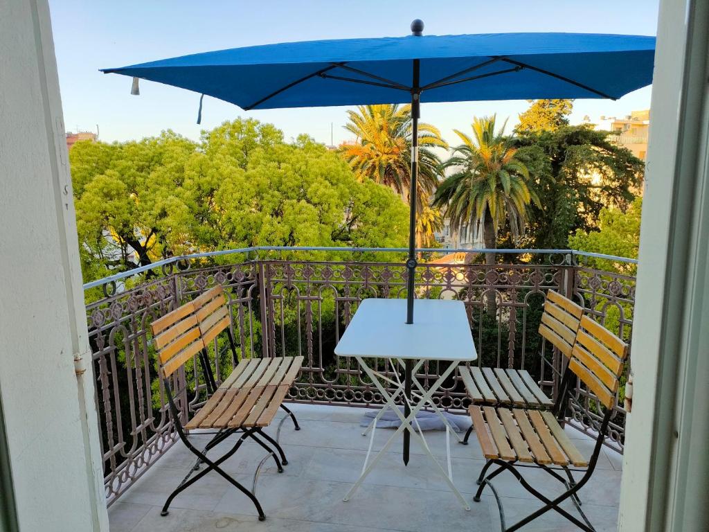 - une table avec deux chaises et un parasol sur le balcon dans l'établissement 3 rooms, 2 bathrooms, in a villa. Lightfull, quiet and charm, à Cannes
