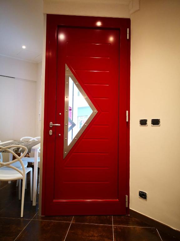 czerwone drzwi z oknem w pokoju w obiekcie La Porta Rossa w mieście Vado Ligure