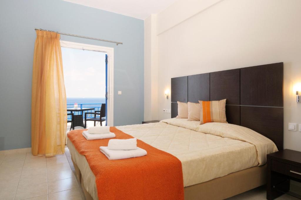 a bedroom with a large bed with a view of the ocean at Kythera Irida in Agia Pelagia