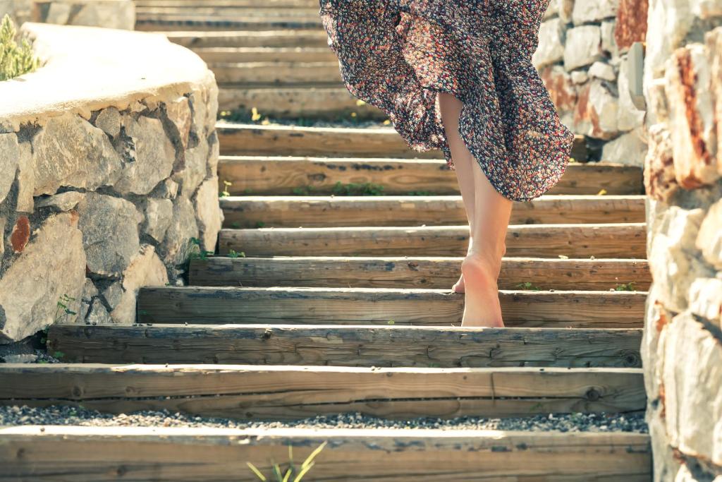 a woman is walking up the stairs at The Olive Yard in Gythio