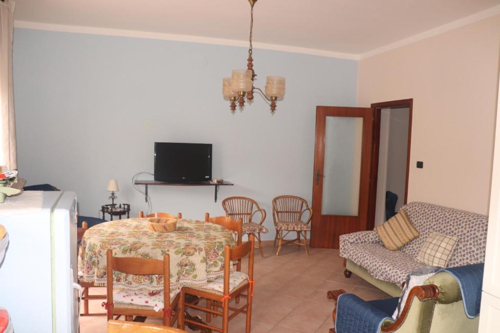 een woonkamer met een tafel en stoelen en een televisie bij Dolce Rita in Galatina