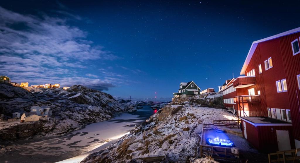 a view of a river at night with buildings at HOTEL SØMA Sisimiut in Sisimiut