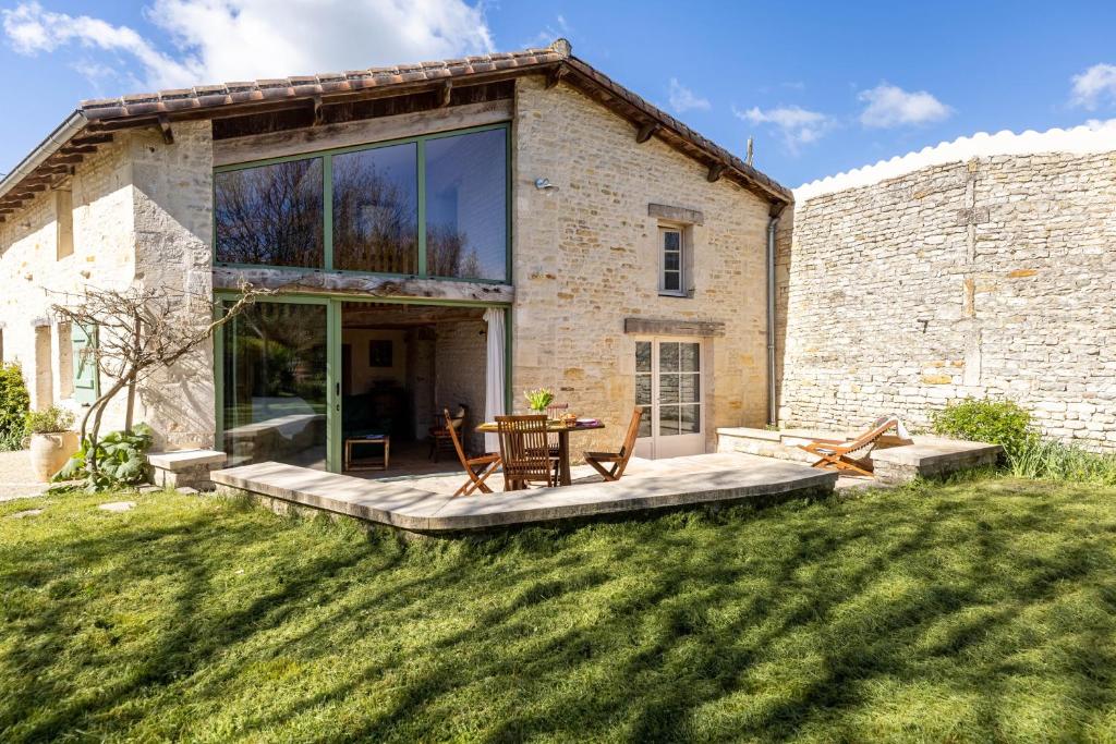 Cette maison dispose d'une terrasse et d'une table dans la cour. dans l'établissement Le Moulin de Granzay, à Granzay-Gript