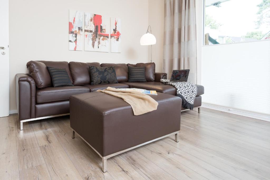 un sofá de cuero marrón en la sala de estar en Haus Meeresbrise - Ferienwohnung 04 Strandnah, en Juliusruh