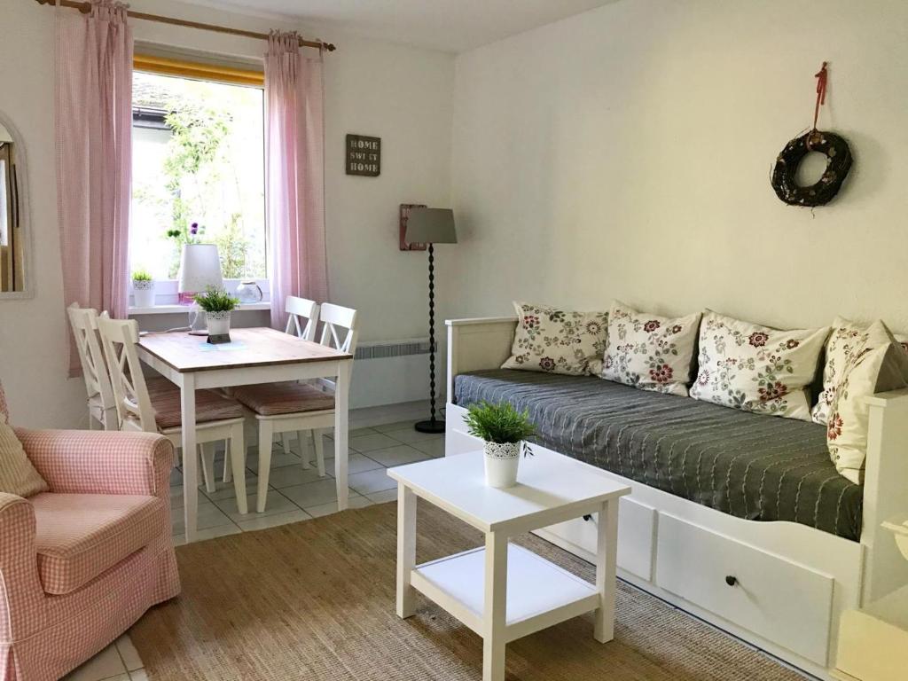 una sala de estar con un sofá y una mesa en Bungalow 68 am Waldrand, en Glowe