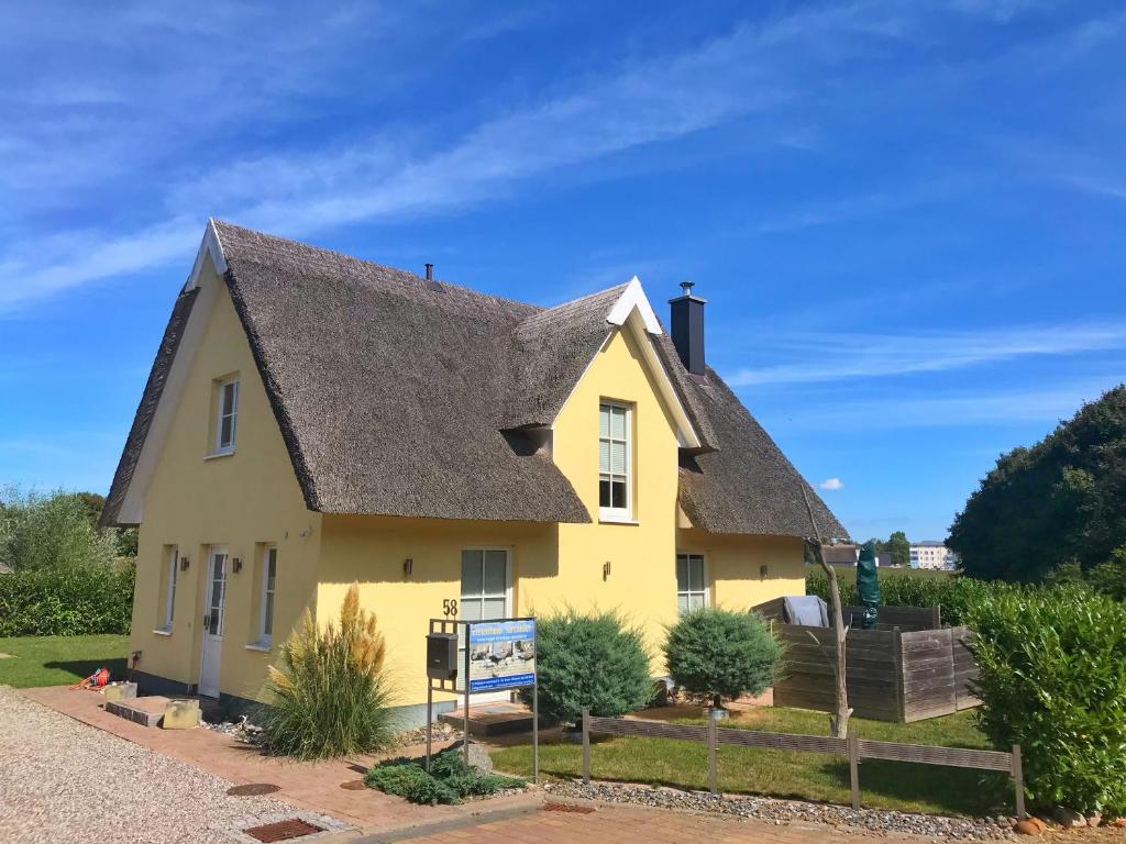a yellow house with a gray roof at Ferienhaus Sarcander in Glowe
