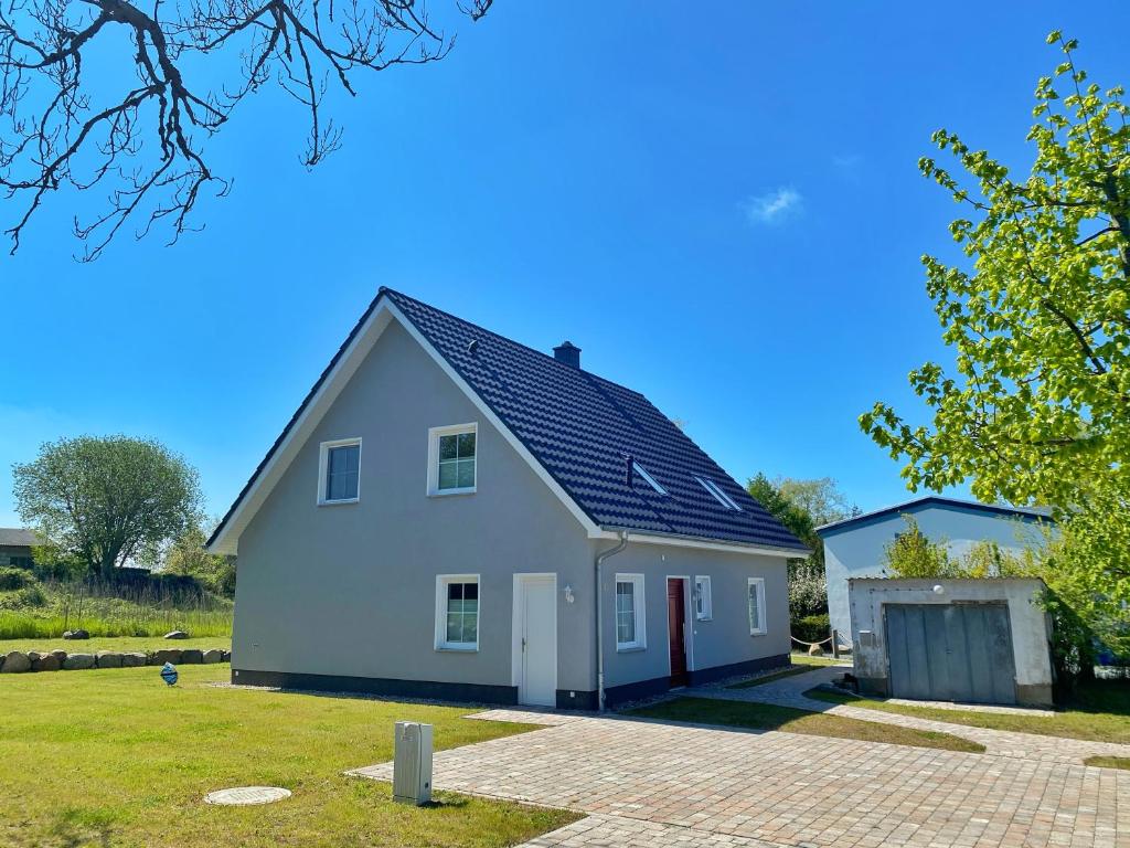 ein weißes Haus mit schwarzem Dach in der Unterkunft Polchow Ferienhaus, Ferienwohnung OG in Polchow