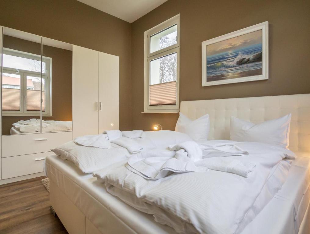 een groot wit bed in een slaapkamer met 2 ramen bij Sassnitz Villa Gössel, WE 3 RZV in Sassnitz