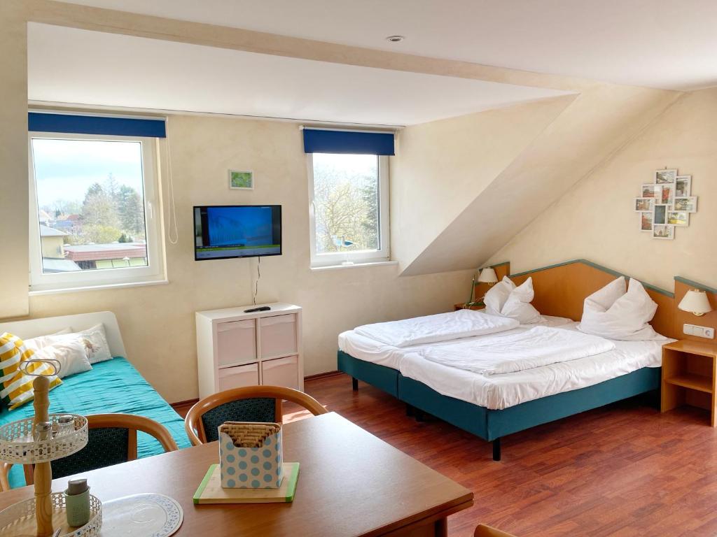 a bedroom with a bed and a tv and a table at Wiek Hafenresidenz App 35 RZV in Wiek auf Rügen 
