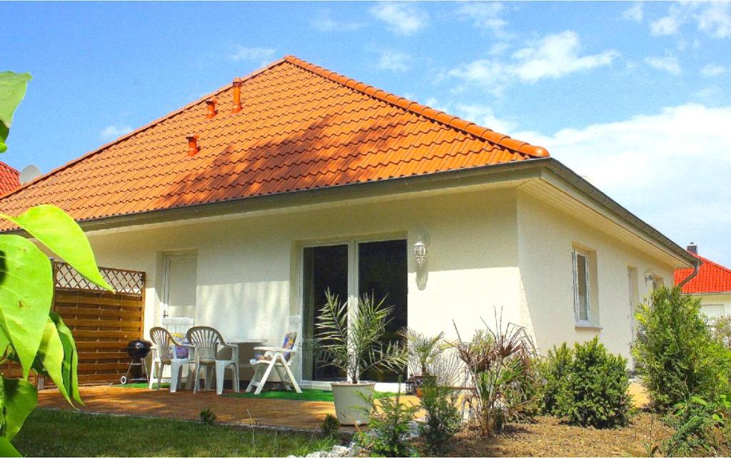 une petite maison blanche avec un toit orange dans l'établissement Staphel - Haus Seeadler, à Staphel