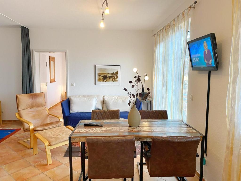 salon ze stołem i niebieską kanapą w obiekcie Sassnitz Villa Tizian Wohnung 9 RZV w mieście Sassnitz