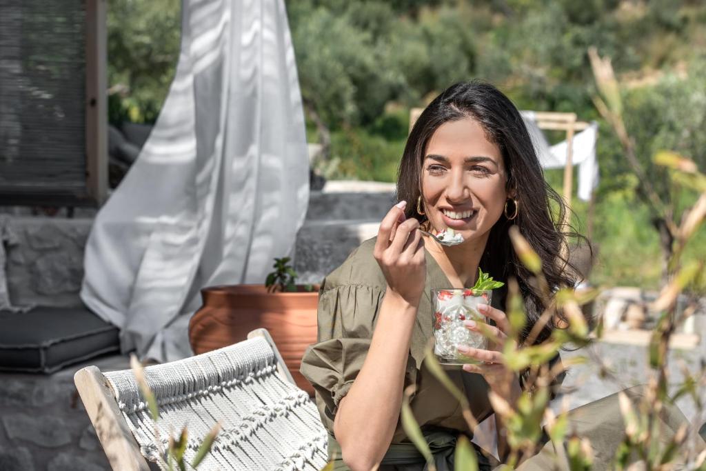 a woman talking on a cell phone while holding a drink at The Olive Yard in Gythio