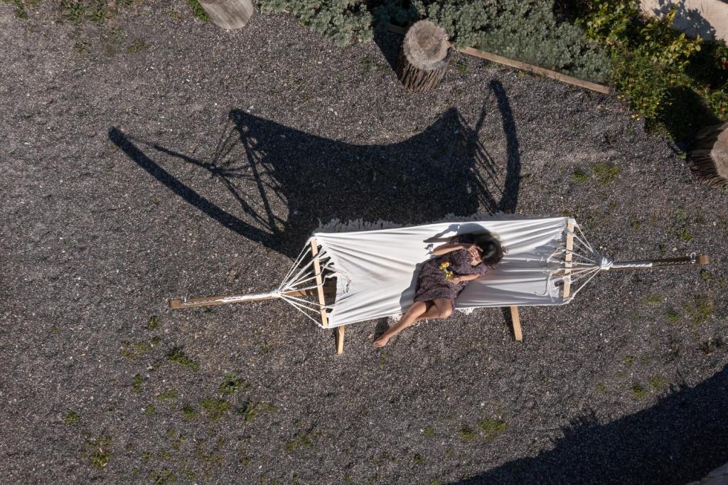 a person sitting on a chair with an umbrella at The Olive Yard in Gythio