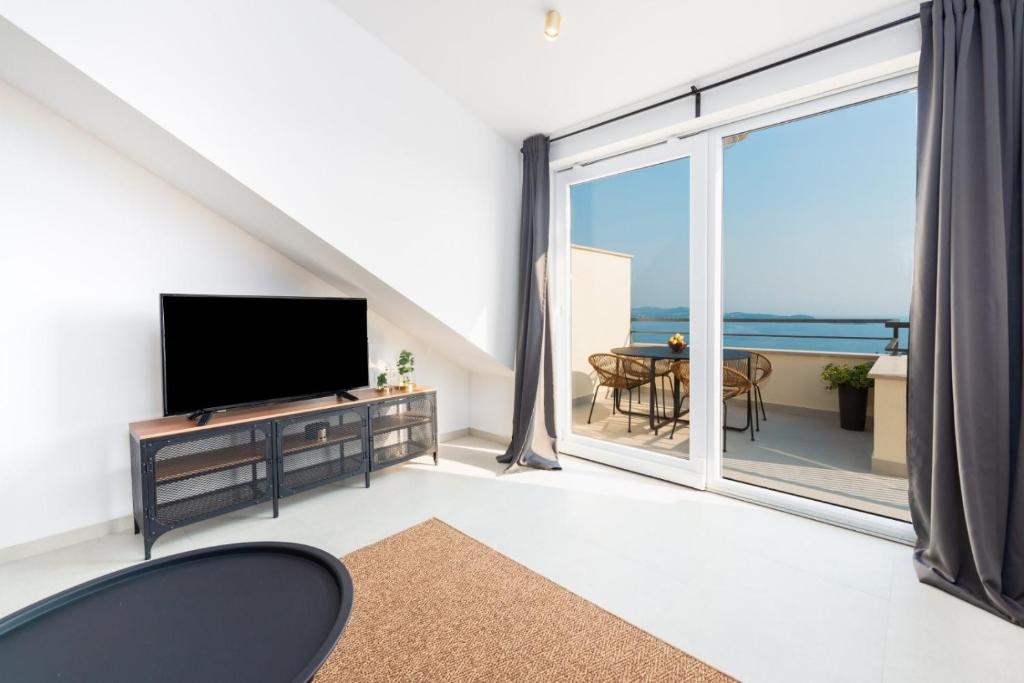 Televízia a/alebo spoločenská miestnosť v ubytovaní Apartment Divine with sea view
