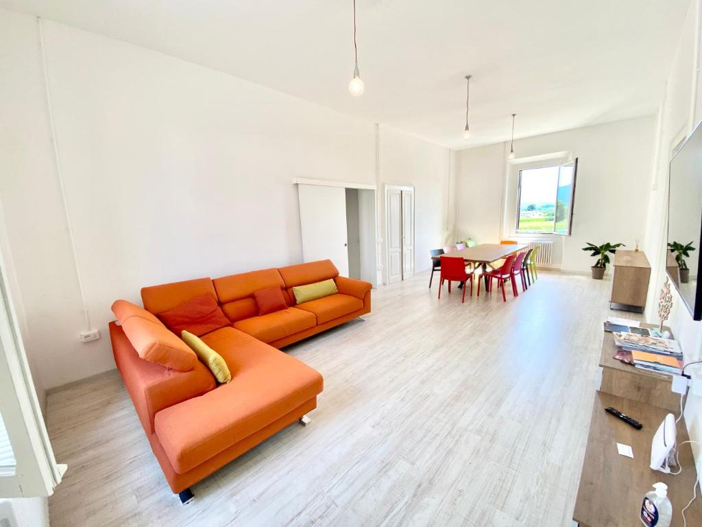 a living room with an orange couch and a table at BRIBANO HOSTEL & bike sharing-workers and tourists hospitality in Sedico