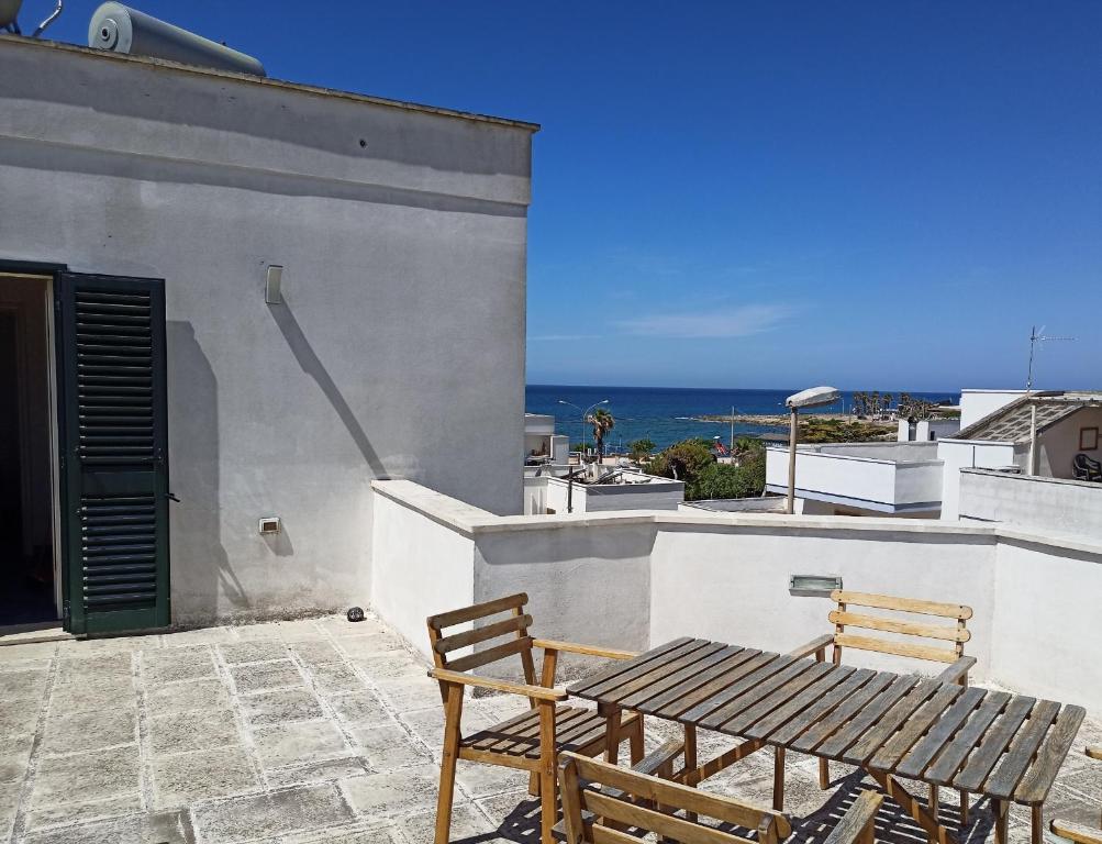a patio with two chairs and a table on a building at Casa Vacanza in Torre San Giovanni Ugento