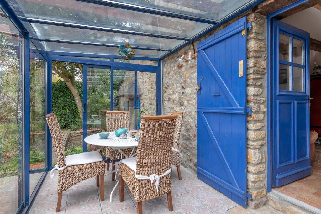 a patio with a blue garage door and a table and chairs at Golfe du Morbihan, Maison de charme pour 6 in Sarzeau