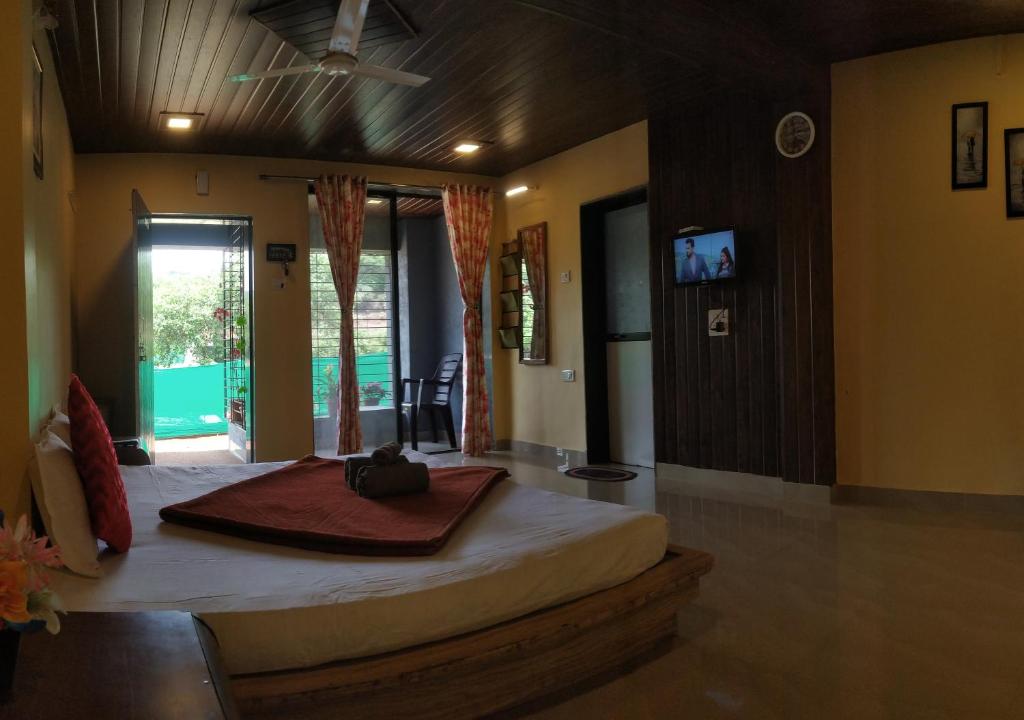 - une chambre avec un grand lit dans l'établissement Bluebell Residency, à Mahabaleshwar