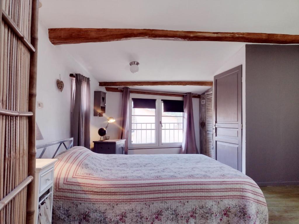 une chambre avec un grand lit et une fenêtre dans l'établissement Verdon charmante maison de ville, à Riez