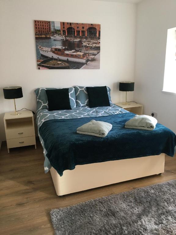 a bedroom with a large bed with a blue blanket at Moden 1-bedroom flat perfect for match / city break in Liverpool
