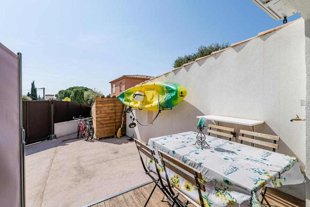 een patio met een tafel en een boot aan een muur bij Chez Pierrot in Bandol