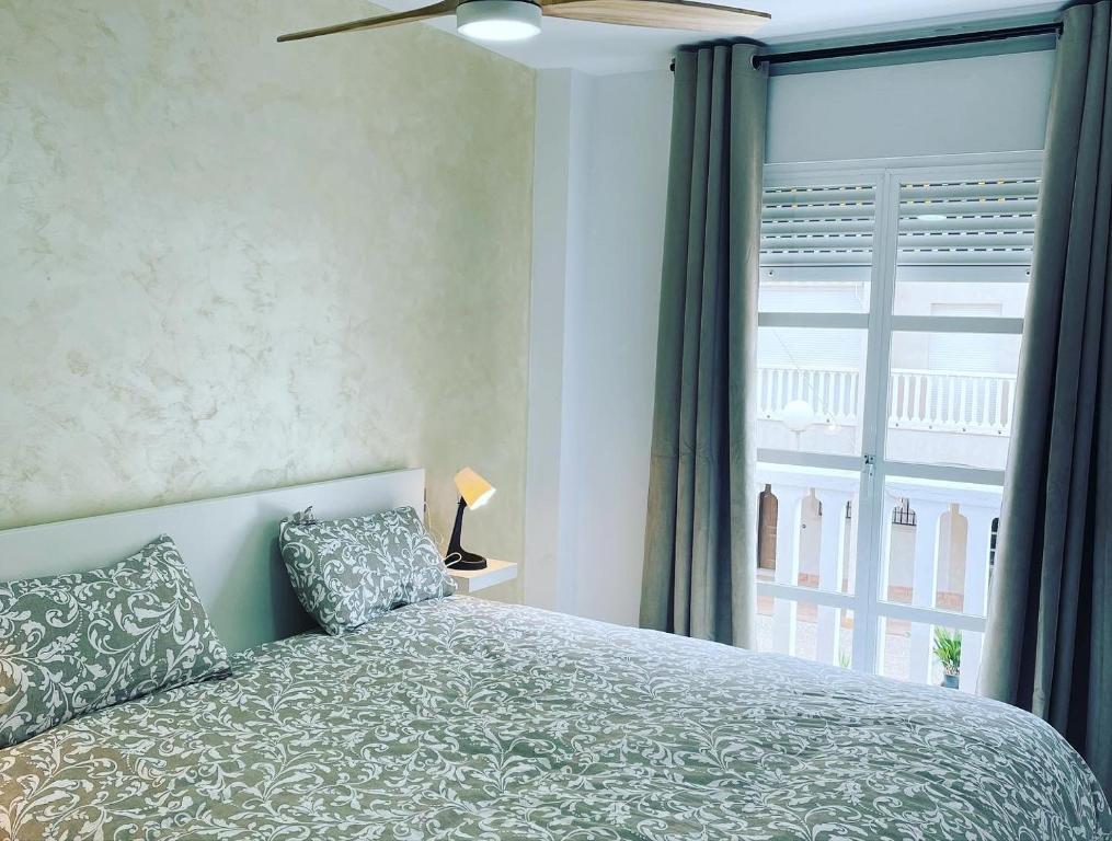 sypialnia z łóżkiem i dużym oknem w obiekcie BALCON PLAYA Y PISCINA 2 Habitaciones IPANEMA PONDOS w Almuñécar