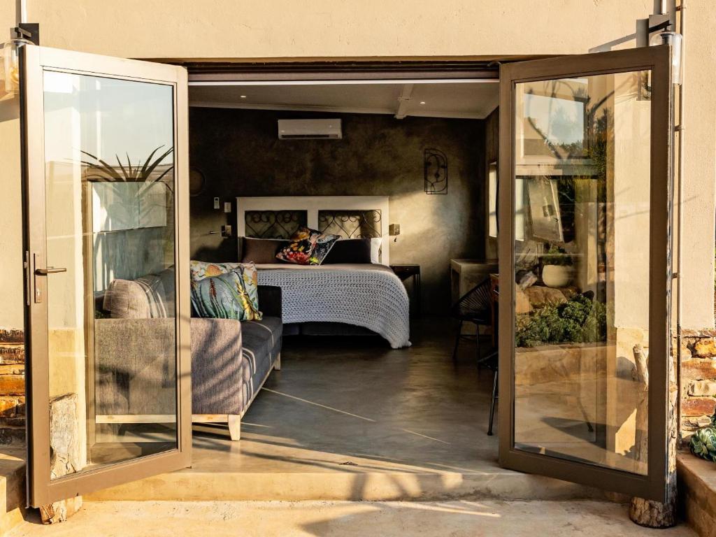 a room with a bedroom with a bed and a mirror at Guest Room at Joubert in Piet Retief