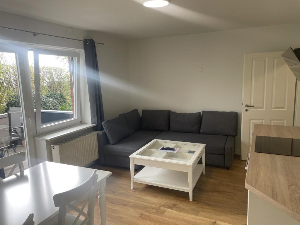 ein Wohnzimmer mit einem Sofa und einem Tisch in der Unterkunft Schleiblick App 14 in Rabenkirchen-Faulück