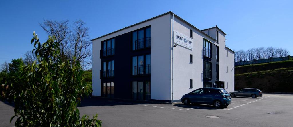 a car parked in a parking lot in front of a building at Smart & Stay Aparthotel Saarlouis Lisdorf - Self-Check-In - Free Parking in Saarlouis