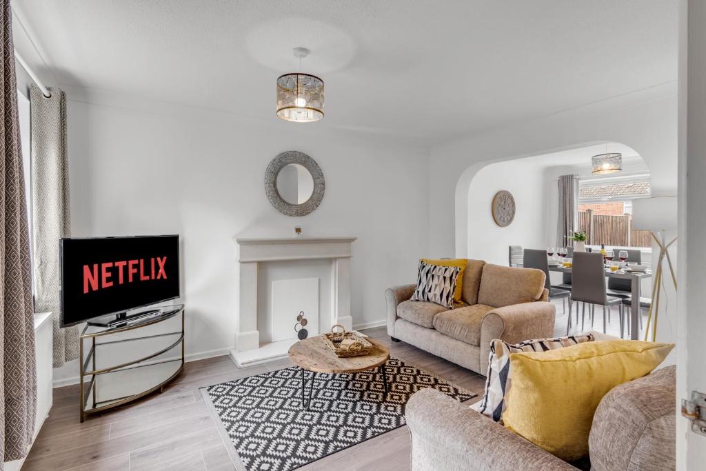 a living room with a couch and a tv at Guest Homes - Galley Lodge in Norwich