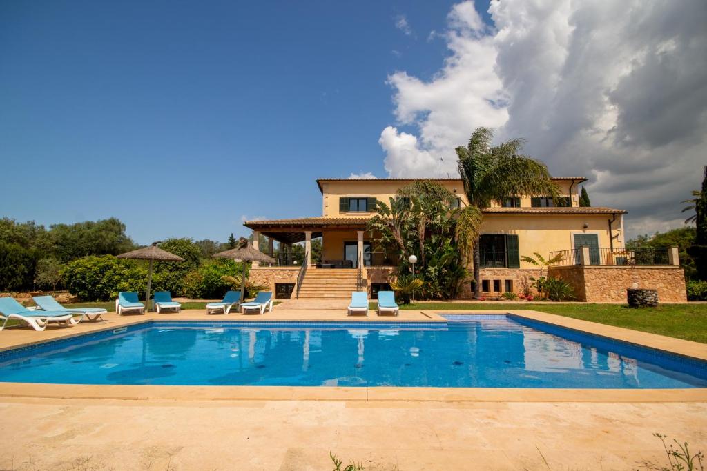 a villa with a swimming pool in front of a house at Ses Salines - 38370 Mallorca in Ses Salines