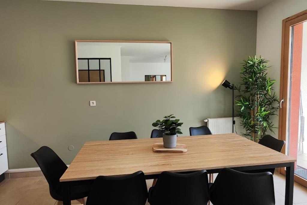 a dining room table with chairs and a mirror at Le Cosy green - Appart 3ch + balcon - neuf in Saint Etienne