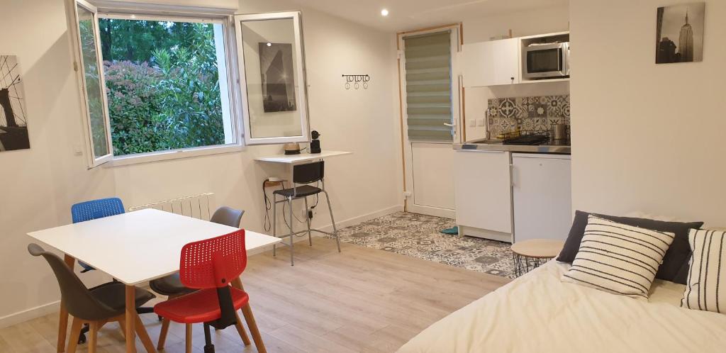 マルセイユにあるAdorable studio 25m² très calme avec parkingのベッド、テーブル、椅子が備わる小さな客室です。