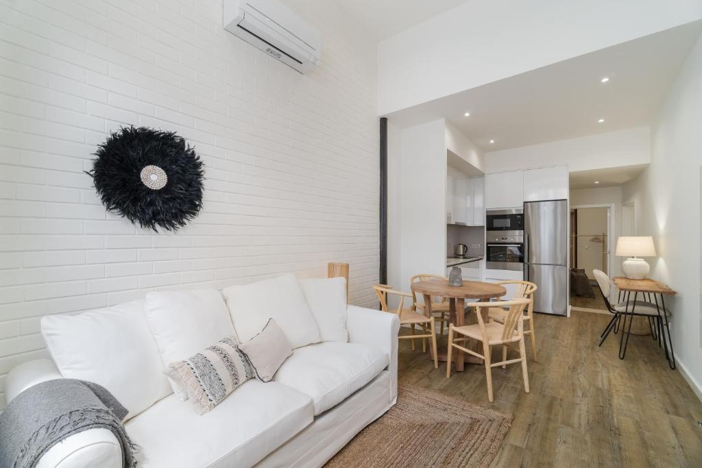 a living room with a white couch and a table at Casa Boma Lisboa - Design Apartment with Private Vegetal Terrace - Lapa VII in Lisbon