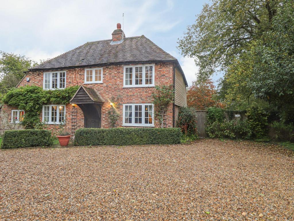 a brick house with a driveway in front of it at Shepherd Cottages luxury self catering in heart of Kent in Lenham