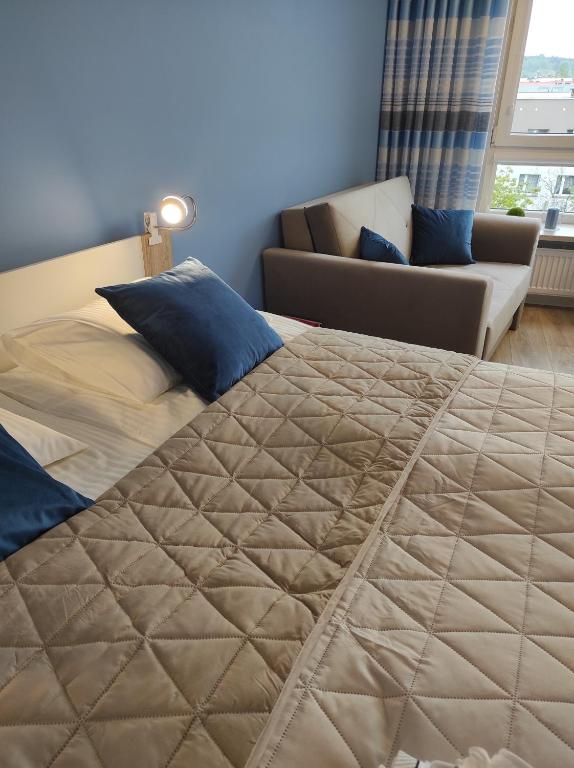 a bed in a room with a couch and a bed sidx sidx sidx at Blue Sky - apartament z pięknym widokiem na górę Telegraf in Kielce