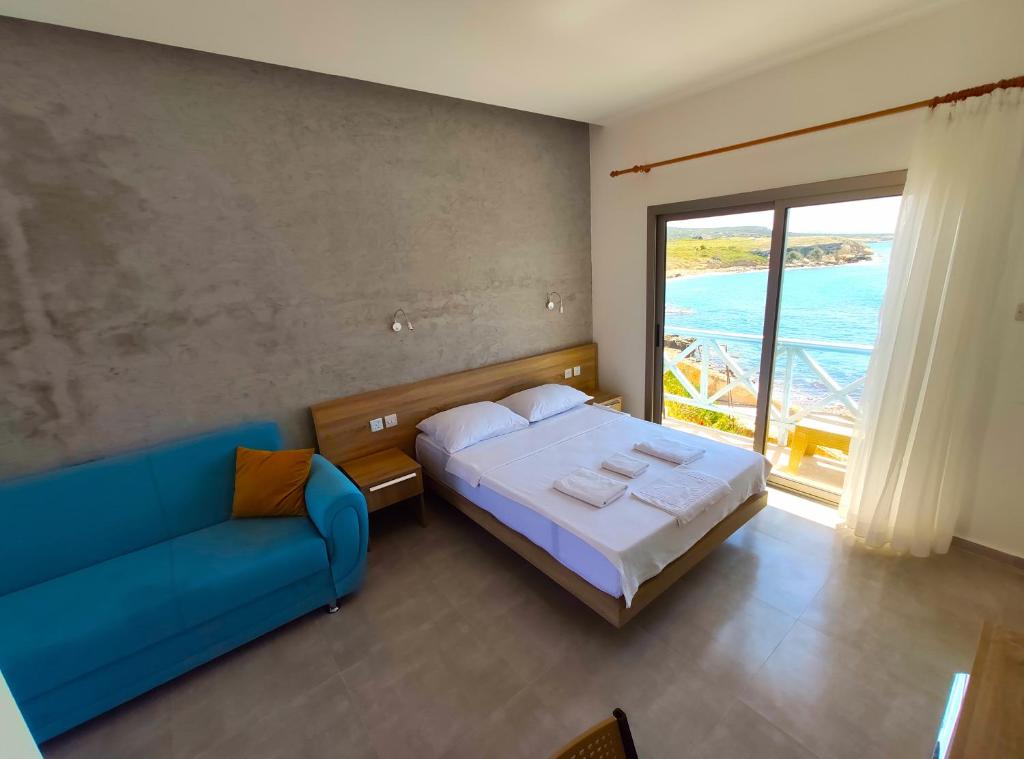 ein Schlafzimmer mit einem Bett und einem blauen Sofa in der Unterkunft OASİS AT AYFİLON in Rizokarpaso
