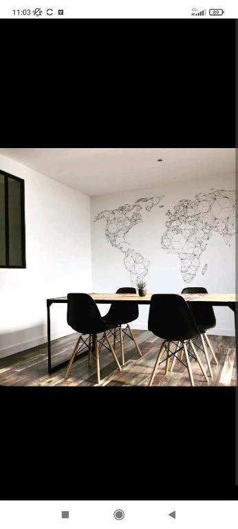 Cette chambre comprend une table avec des chaises et une carte du monde sur le mur. dans l'établissement Appartement de style à l'exceptionnelle vue mer !!, à Le Relecq-Kerhuon